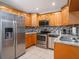 Updated kitchen with stainless steel appliances, wood cabinets, granite countertops, and tile backsplash at 8210 Marigold Ave, Tampa, FL 33614
