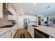 Modern kitchen featuring white cabinets, stainless steel appliances, granite countertops, and an island sink at 8314 Capstone Ranch Dr, New Port Richey, FL 34655