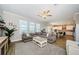 Spacious living room featuring wood-look tile flooring, large windows, crown molding, and an open floor plan at 8314 Capstone Ranch Dr, New Port Richey, FL 34655