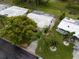 Aerial view of the house with a white roof, surrounded by lush greenery and palm trees at 9082 141St St, Seminole, FL 33776