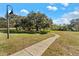 A well-maintained path leads into a spacious neighborhood park with mature trees and recreational space at 968 Edgehill Dr, Palm Harbor, FL 34684