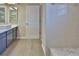 Bathroom featuring gray cabinets, a white shower and wood plank floors at 1093 Muirfield Ct, Tarpon Springs, FL 34688