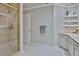 Bright bathroom featuring a glass enclosed shower, white cabinets, and open shelves at 1093 Muirfield Ct, Tarpon Springs, FL 34688