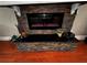 Close-up of stone fireplace with decorations and hardwood floors at 1093 Muirfield Ct, Tarpon Springs, FL 34688