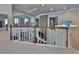 Open hallway with decorative railings and views of the living area and stone fireplace at 1093 Muirfield Ct, Tarpon Springs, FL 34688