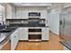 Modern kitchen features stainless steel appliances, granite counters, and tile backsplash at 1093 Muirfield Ct, Tarpon Springs, FL 34688