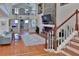 Bright living room with hardwood floors, a fireplace, and open access to the upper level and other living areas at 1093 Muirfield Ct, Tarpon Springs, FL 34688