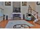 Bright living room featuring stone fireplace, hardwood floors, and staircase to the second level at 1093 Muirfield Ct, Tarpon Springs, FL 34688