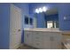 Light blue bathroom featuring double sinks, white cabinets, and an oversized mirror at 12720 Whitney Meadow Way, Riverview, FL 33578