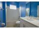 Blue bathroom with tiled shower, white vanity, and coordinating commode and tile flooring at 12720 Whitney Meadow Way, Riverview, FL 33578