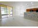 Living area with large sliding glass doors and breakfast bar with stone accents at 12720 Whitney Meadow Way, Riverview, FL 33578