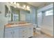 Bathroom featuring double vanity with granite counters, large mirror and shower and tub combo at 13016 Sanctuary Cove Dr # 201, Temple Terrace, FL 33637
