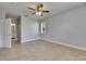Spacious bedroom featuring tile floors, a ceiling fan, and a view to the bathroom at 13016 Sanctuary Cove Dr # 201, Temple Terrace, FL 33637