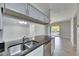 Kitchen with dark countertops, a stainless sink and dishwasher, and views to the living room at 13016 Sanctuary Cove Dr # 201, Temple Terrace, FL 33637