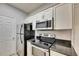 Kitchen featuring granite countertops, stainless steel appliances, and white cabinets at 13016 Sanctuary Cove Dr # 201, Temple Terrace, FL 33637