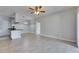 Open living area with tile flooring and a view into the kitchen with light gray cabinets at 13016 Sanctuary Cove Dr # 201, Temple Terrace, FL 33637