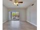 Bright living room with a ceiling fan and sliding glass doors leading to the outdoor balcony at 13016 Sanctuary Cove Dr # 201, Temple Terrace, FL 33637