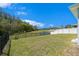 Backyard view with a black fence, lush green lawn, and a pond in the distance with surrounding trees at 1439 Gopher Loop, Tarpon Springs, FL 34689