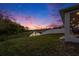 Backyard with a pond view and a covered patio with furniture, perfect for relaxing at sunset at 1439 Gopher Loop, Tarpon Springs, FL 34689