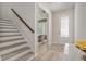 Inviting entryway featuring light wood floors, stairs with dark wood handrail, and a glimpse into a home office at 1439 Gopher Loop, Tarpon Springs, FL 34689