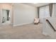 Relaxing sitting area featuring neutral carpet, chair, and natural light, creating a serene and inviting atmosphere at 1439 Gopher Loop, Tarpon Springs, FL 34689