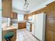 Functional kitchen with wood cabinets, white appliances, and tile flooring at 160 16Th Ne Ave, St Petersburg, FL 33704