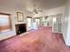 Spacious living room featuring a brick fireplace, bright windows, and carpeted flooring at 160 16Th Ne Ave, St Petersburg, FL 33704