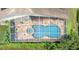 Overhead view of the screened-in pool with a spa and lounge area, surrounded by lush greenery at 17503 Edinburgh Dr, Tampa, FL 33647