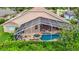 Aerial view of screened-in pool and patio, with hot tub, outdoor seating, and lush backyard landscaping at 17503 Edinburgh Dr, Tampa, FL 33647