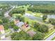 Beautiful aerial shot of a property in a serene, golf course community surrounded by mature trees and a lake at 17503 Edinburgh Dr, Tampa, FL 33647