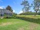 View of backyard and screen enclosed pool area, with an open lawn and bordering golf course in the distance at 17503 Edinburgh Dr, Tampa, FL 33647