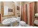 Classic bathroom with detailed framed mirror, pedestal sink, and a shower with curtain at 17503 Edinburgh Dr, Tampa, FL 33647