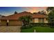 Charming single-story home featuring a well-manicured lawn, mature landscaping, and an attached two-car garage at 17503 Edinburgh Dr, Tampa, FL 33647