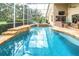 Inviting screened-in pool area with a waterfall feature, jacuzzi, and ample seating for outdoor relaxation at 17503 Edinburgh Dr, Tampa, FL 33647