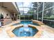 Inviting screened-in pool area with stone accents and lush landscaping at 17503 Edinburgh Dr, Tampa, FL 33647