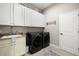 Laundry room featuring side-by-side washer and dryer units and ample cabinet space at 17909 Howsmoor Pl, Lutz, FL 33559