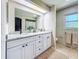 Bright bathroom featuring a double vanity with granite countertop and white cabinets at 19032 Duncan Ct, Dade City, FL 33523