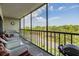 Balcony featuring wicker furniture and a BBQ grill, with views of mature trees and a road at 2700 Cove Cay Dr # 5-G, Clearwater, FL 33760