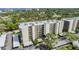 Exterior view of a condominium building with well-maintained landscaping and covered parking in a lush green setting at 2700 Cove Cay Dr # 5-G, Clearwater, FL 33760