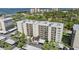 Exterior view of a condominium building with well-maintained landscaping and covered parking in a lush green setting at 2700 Cove Cay Dr # 5-G, Clearwater, FL 33760