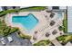 Aerial view of a geometric style pool with a hot tub and lounge chairs surrounded by lush greenery and shade umbrellas at 2700 Cove Cay Dr # 5-G, Clearwater, FL 33760