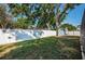 Expansive backyard enclosed with a white fence, showcasing mature trees and manicured lawn at 2736 45Th N Way, St Petersburg, FL 33713