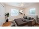 Airy bedroom with hardwood floors and two windows with white blinds. Includes a modern decorative print at 2736 45Th N Way, St Petersburg, FL 33713
