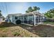 Screened-in porch with ceiling fans, dining set, and backyard view, adjacent to grill and outdoor amenities at 2736 45Th N Way, St Petersburg, FL 33713