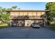 Two-story home with a balcony and three garage spaces, alongside an elegant gold convertible parked in the driveway at 2934 Lichen Ln # D, Clearwater, FL 33760