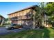 Two-story home with a balcony and three garage spaces, alongside an elegant gold convertible parked in the driveway at 2934 Lichen Ln # D, Clearwater, FL 33760