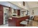 Modern kitchen featuring a stainless steel refrigerator, tiled backsplash, granite counters and a bar with stools at 2934 Lichen Ln # D, Clearwater, FL 33760