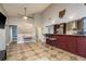 Open-concept living room with a vaulted ceiling, tiled floors, and adjacent kitchen bar seating at 2934 Lichen Ln # D, Clearwater, FL 33760