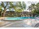 Community pool with lounge chairs surrounded by mature trees and community buildings at 2934 Lichen Ln # D, Clearwater, FL 33760