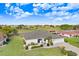 Aerial view of a well-kept home with a lush green lawn, scenic surroundings, and a nearby pond at 303 Cranston Pl, Sun City Center, FL 33573